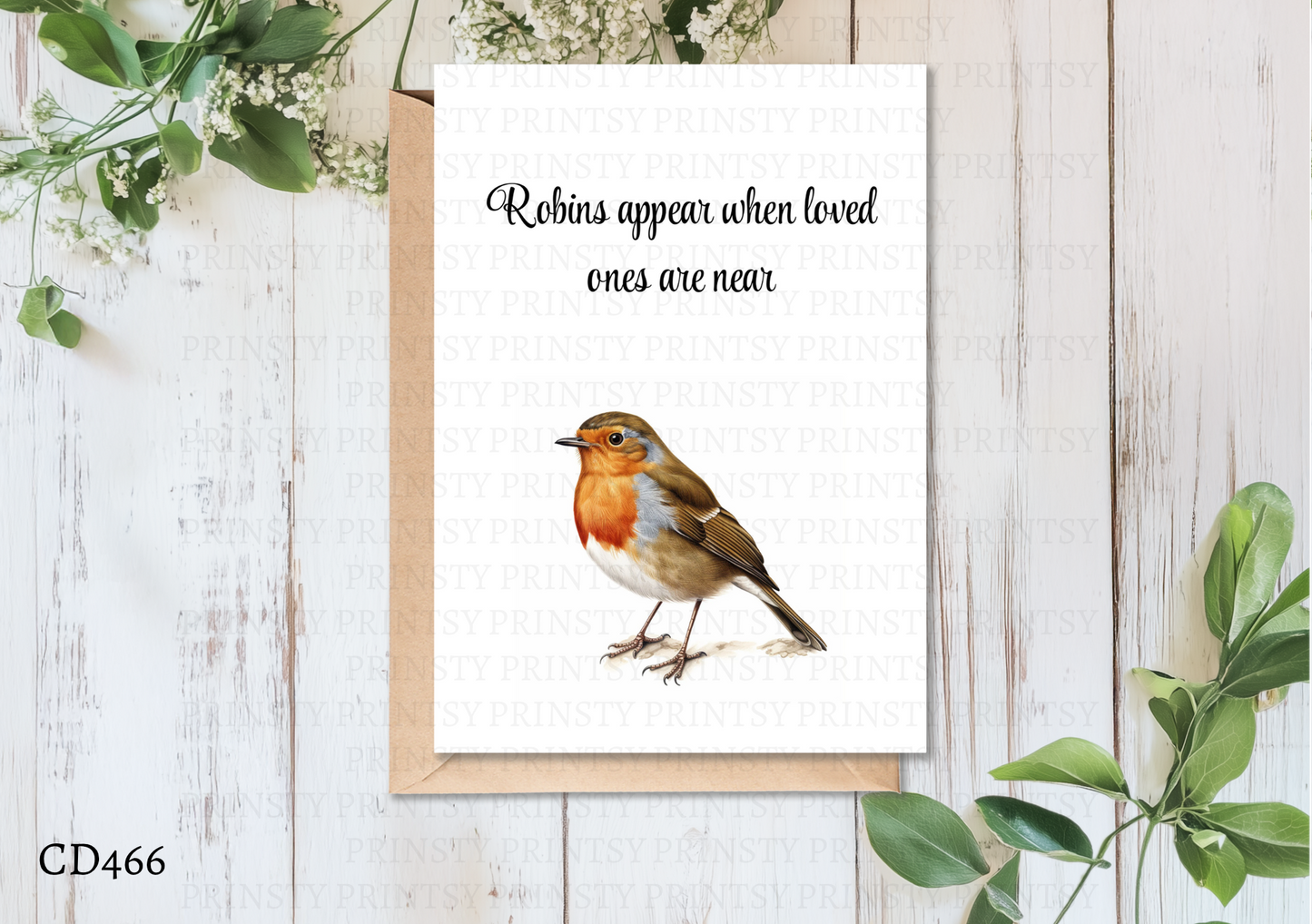 Card with a robin illustration and text on a wooden surface with greenery