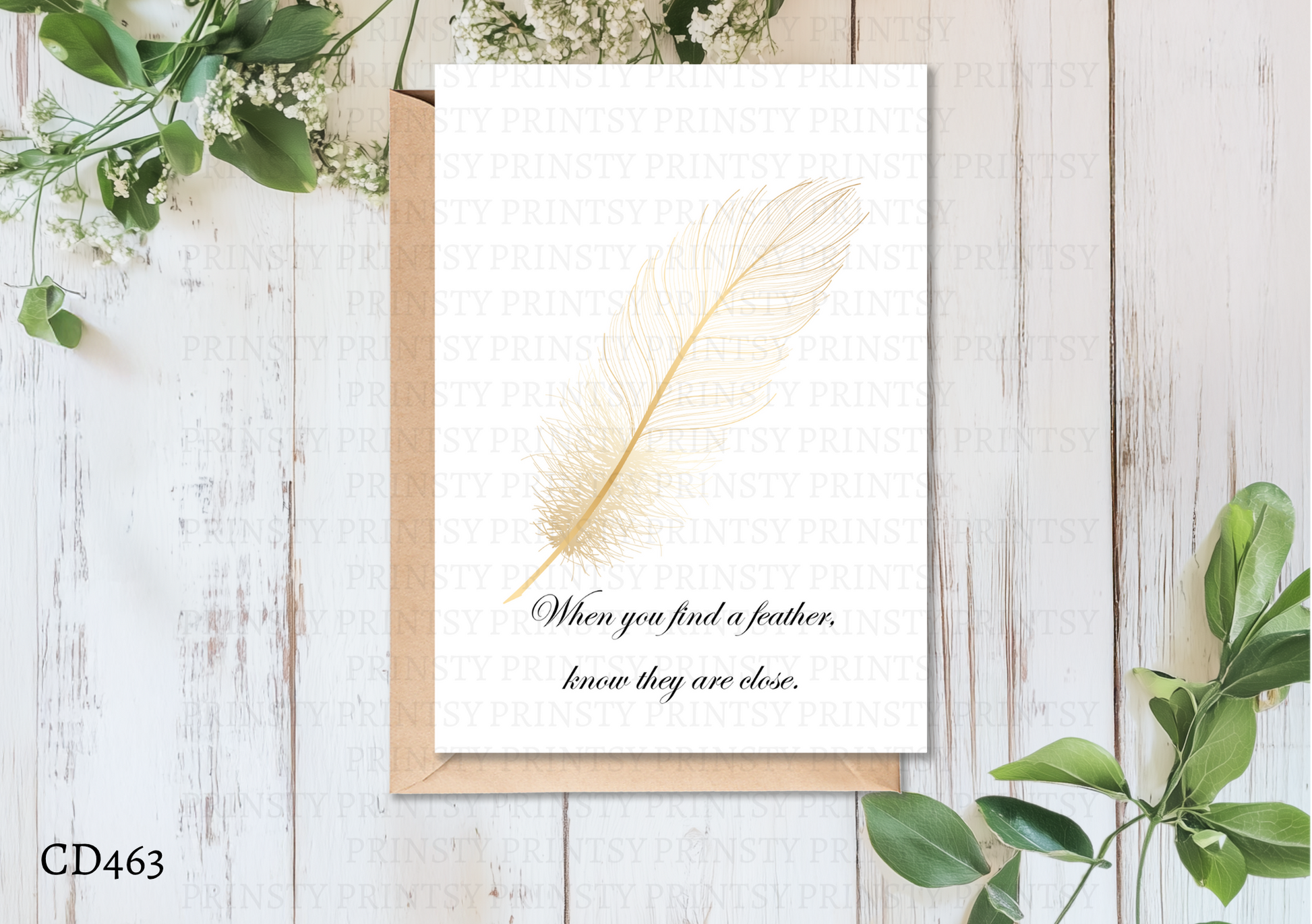 Greeting card with feather and text on a wooden surface with greenery