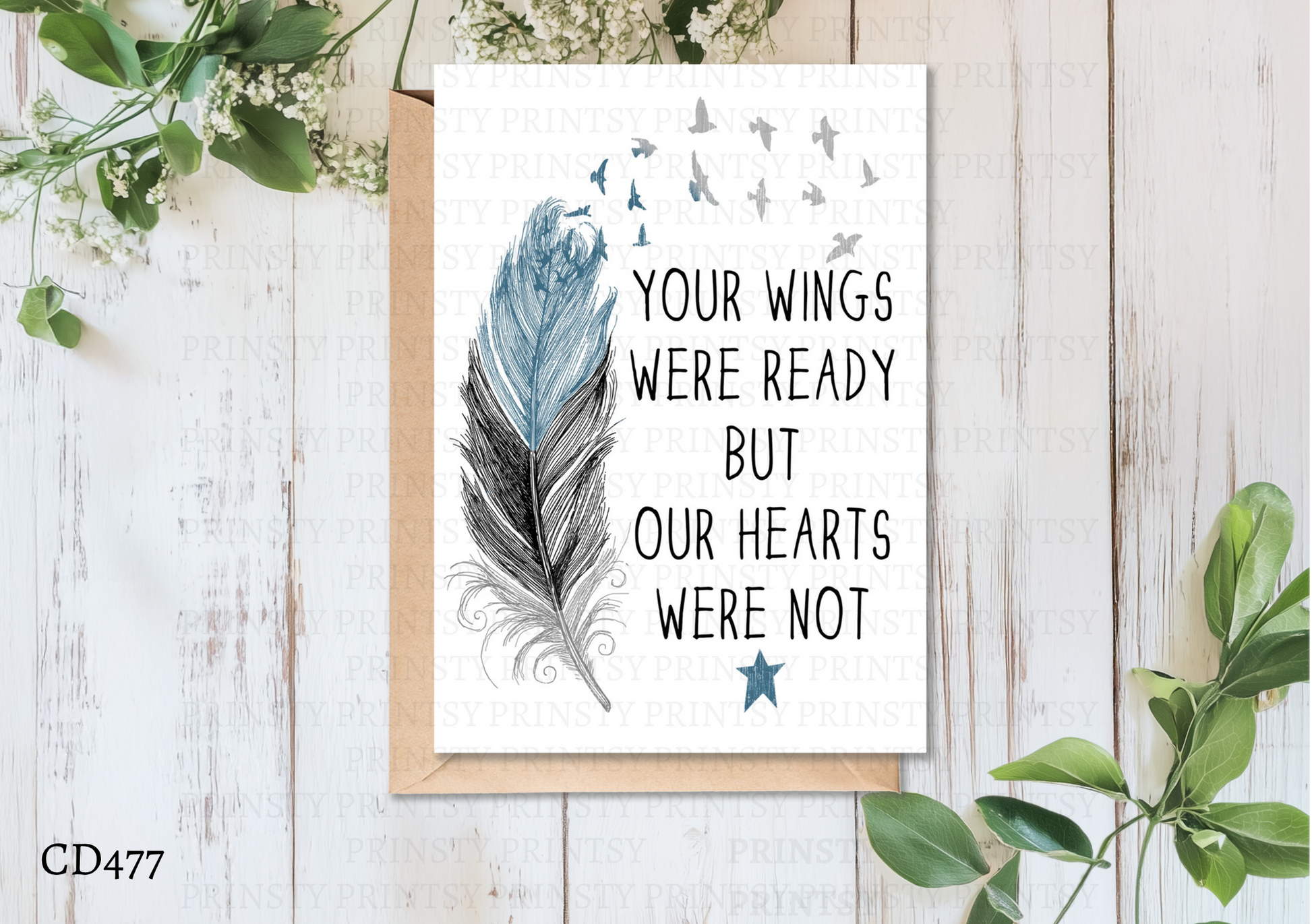 Greeting card with feather design and text on a wooden surface with greenery